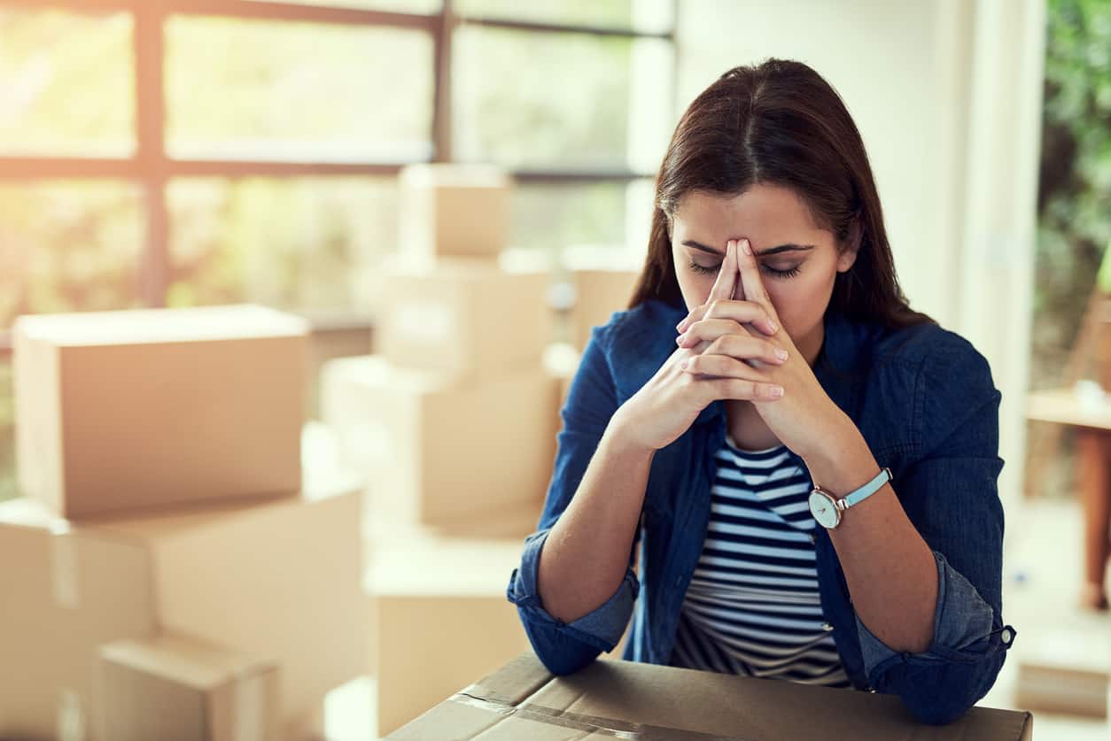 Cropped shot of a young woman looking stressed out while moving house